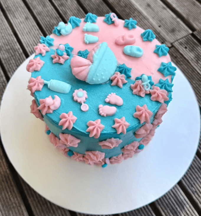Pastelkleurige gender reveal taart met fijne decoratie.